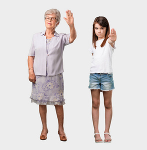 整个身体的老太太和她的孙女认真和坚定, 把手放在前面, 停止手势, 否认概念
