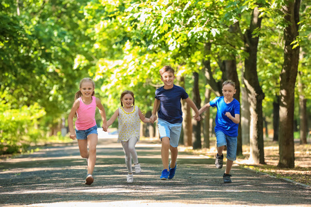 可爱的小朋友在绿色公园玩耍照片
