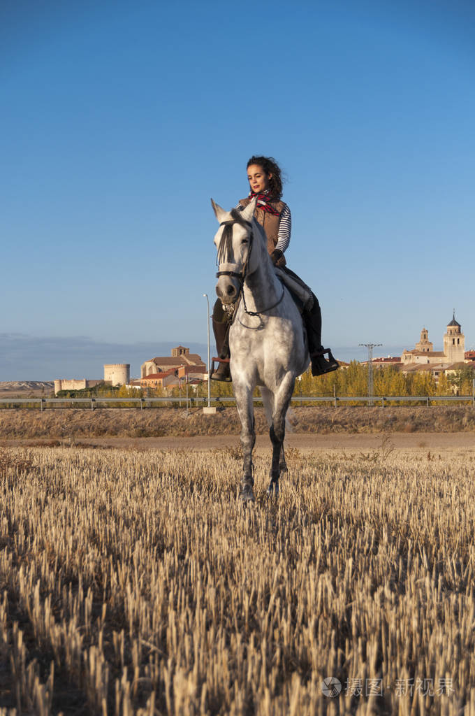 在马背上她的脖子上的手帕的年轻妇女