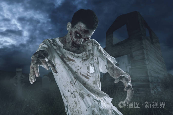 万圣节恐怖的概念.照片的可怕的僵尸男子走在一个废弃的房子附近.