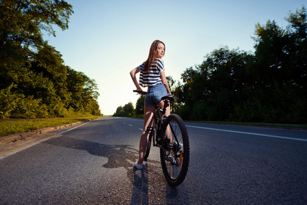 在日落时一辆自行车上的女孩