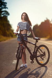 在日落时一辆自行车上的女孩