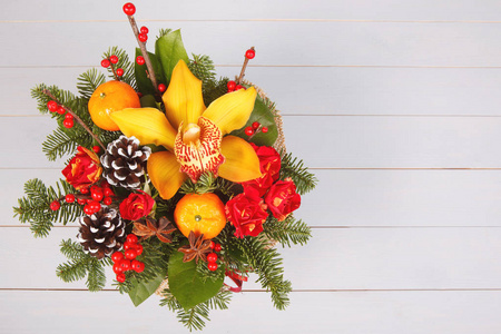 圣诞花束的红色, 黄色的花朵与水果橘子在白色的木质背景