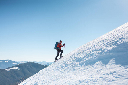 登山运动员在雪地鞋背着一个背包.在冬天的山上旅行.