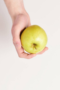 雄手捧着淡绿色的苹果。白色背景下的苹果