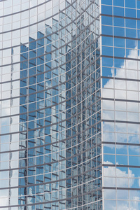 云彩和镜子大厦反射在现代办公室工作空间的窗口。钢光蓝背景玻璃高层商业摩天大楼, 未来城市概念