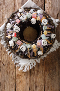 万圣节黑庞德蛋糕上装饰着蜜饯, 棉花糖和琉璃特写在桌子上。从 abov 垂直顶部视图