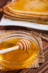 新鲜的蜂蜜与堆栈的薄饼或薄饼