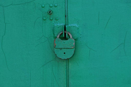 挂在金属门上的大旧铁绿色锁图片