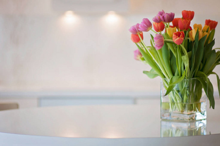 一个白色和干净的家庭办公厨房背景与五颜六色的郁金香花在前面。芬兰典型的斯堪的纳维亚北欧内部