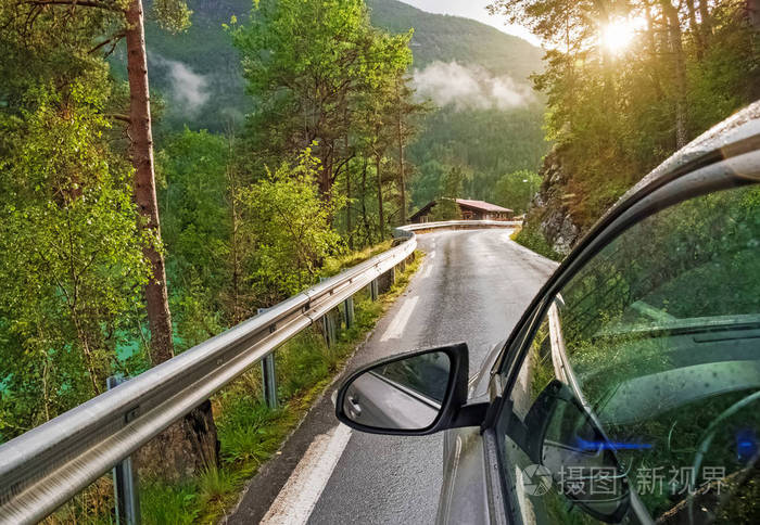 在森林的风景公路上行驶的汽车特写
