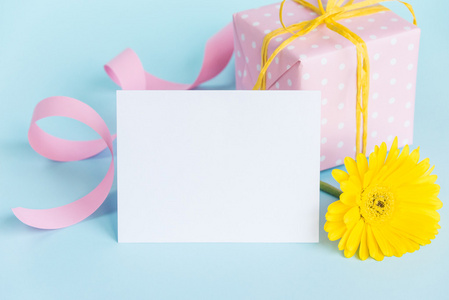 粉色点缀礼品盒，黄太阳菊花卉和空卡在蓝色的背景