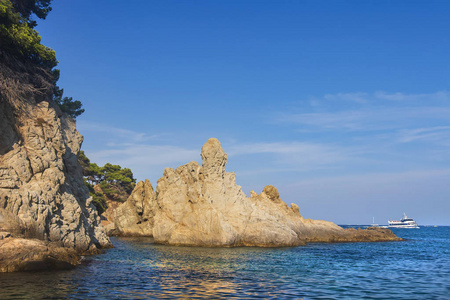 海景与岩石岸边在晴朗晴朗的一天。海岸线附近的巨大岩石。西班牙的哥斯达黎加的性质。海中的野岩石对着湛蓝的天空