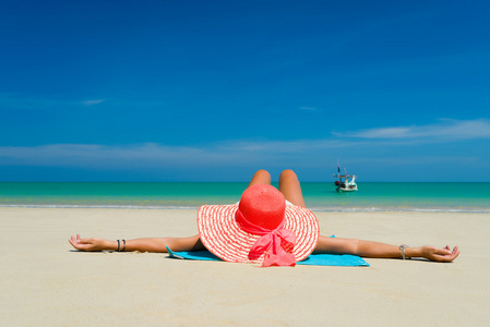 合适的女人在太阳帽子和比基尼在海滩