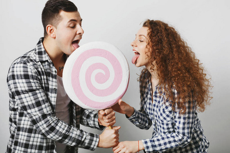 漂亮的卷发女人和她的男朋友与甜糖果照片