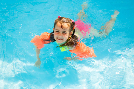 快乐的小女孩在水公园游泳水下和微笑照片