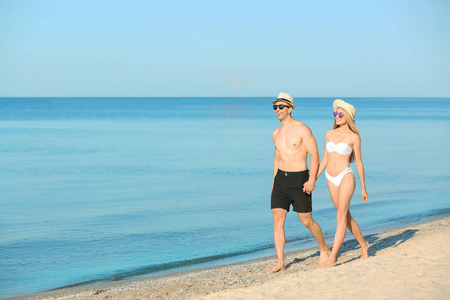 快乐的年轻夫妇在海边漫步