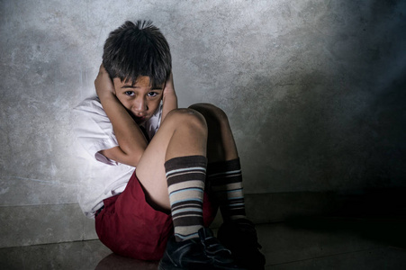 7-10 岁在学校制服独自坐着哭郁闷和害怕遭受虐待问题无助和欺负照片