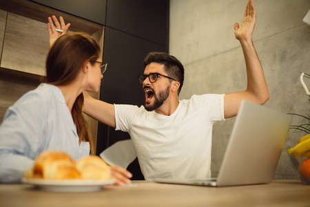 婚姻烦恼愤怒的情侣在厨房里吵架.他们互相喊叫.照片