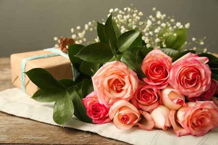 木桌上配有礼品盒的美丽玫瑰花