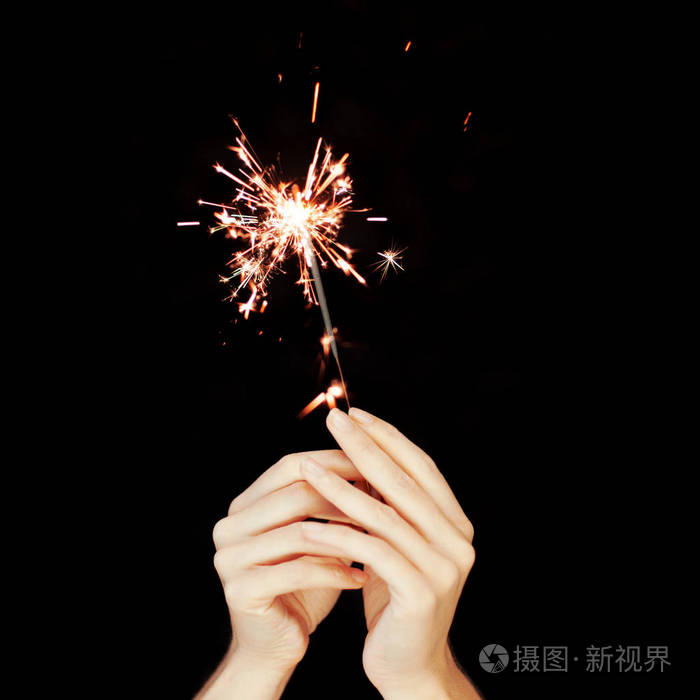 美丽的女人手捧着烟火的灯在黑色的前面, 可以用作背景照片-正版商用