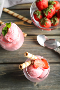 在木质背景下的美味草莓冰淇淋眼镜