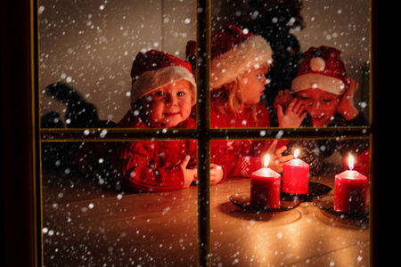 小男孩和女孩在圣诞节前夕看蜡烛照片
