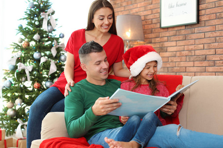 快乐的父母和孩子一起在圣诞节一起阅读童话故事