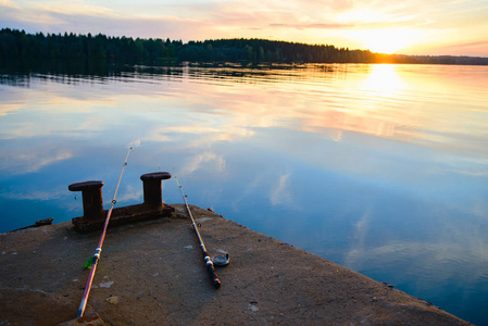 钓鱼竿躺在河边的码头上。