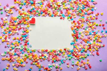 彩色背景下的空白卡和不同的心形糖果