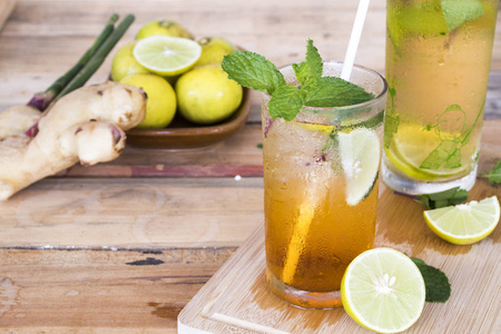 柠檬茶饮品草药健康饮料冷柠檬汁和柠檬茶保健与薄荷叶和柠檬片背景木