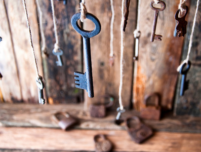 很多钥匙挂在一个字符串。木制的背景。选择性的焦点