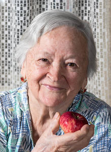 满脸笑容的老妇抱着红红的苹果