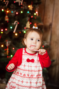 可爱的女孩吃扭曲圣诞糖果手杖