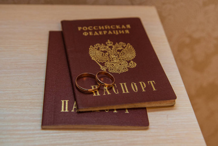 结婚戒指新娘和新郎的两个金色浪漫戒指和俄罗斯联邦护照