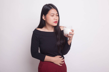 亚洲女人喝一杯牛奶肚子痛在白色背景上照片