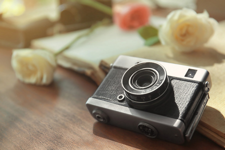 老式相机和美丽的玫瑰花上打开相册照片