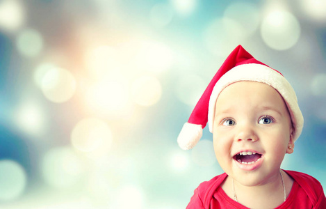 儿童女孩快乐的笑脸在圣诞老人的帽子空的空间圣诞背景