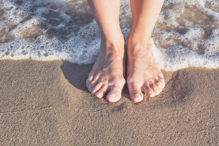 女人的腿在沙滩上