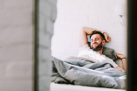 年轻人早晨醒来在床上照片