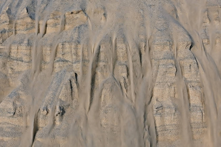 沙丘淹没的沙子纹理。沙丘上的沙子雪崩