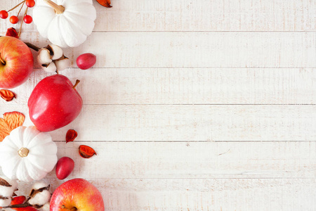 红色和白色主题秋天边与苹果和南瓜在白色木头背景。复制空间