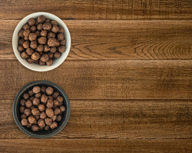 碗与巧克力玉米球早餐在木质背景。健康的谷类素食食品的顶部视图, 文本或产品广告的空间