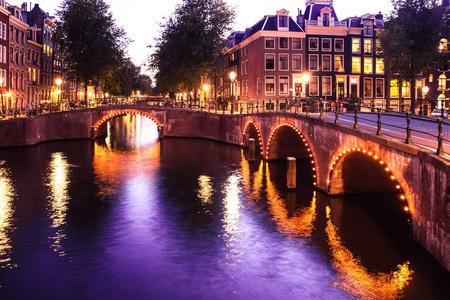 阿姆斯特丹晚上与桥梁, 运河和灯在日落
