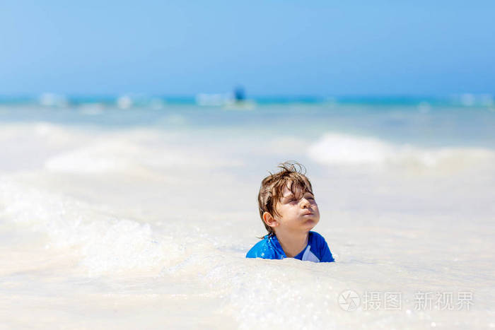 在马尔代夫热带海滩上玩耍的小男孩金发碧眼的孩子