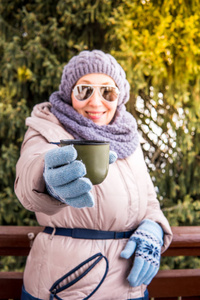 老妇人在露天的热水瓶里喝茶图片