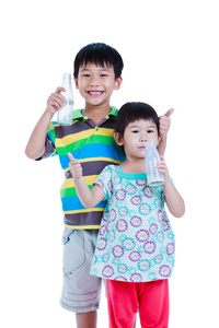 两个亚洲男孩和女孩喝牛奶上白色, 孤立。喝牛奶对健康有益
