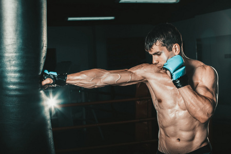 年轻男性拳击手在健身房中使用一个出气筒