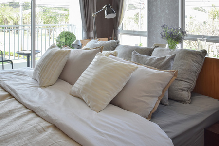 与白色条纹枕头在床上和装饰台灯时尚卧室室内设计