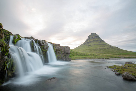 在冰岛山之间的瀑布从河春天